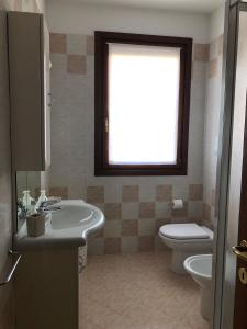a bathroom with a sink and a toilet and a window at HOME NUOVA OSTIGLIA in Padernello