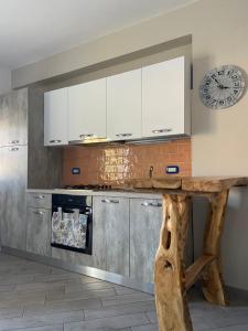 cocina con mesa y reloj en la pared en Casa vacanze Brezza di mare, en Tortora