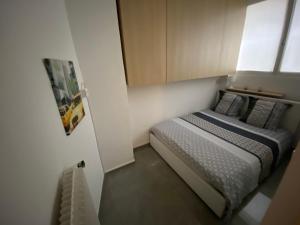 ein kleines Schlafzimmer mit einem Bett in einem Zimmer in der Unterkunft Cosy 2 pièces, résidence en front de mer, Roquebrune Cap Martin in Roquebrune-Cap-Martin