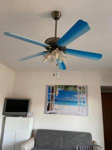 un ventilatore a soffitto in un soggiorno con divano di Casa vacanze Brezza di mare a Tortora