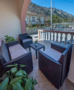 un patio con sedie e tavoli in vimini sul balcone. di Apartment Vento di Bocche II a Kotor (Cattaro)