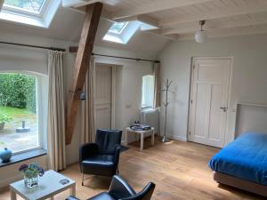 a bedroom with a bed and a chair and a window at Duerswald in Wijnjewoude