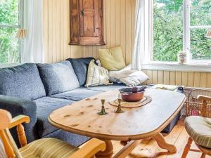 sala de estar con sofá azul y mesa de madera en Holiday home FLEN IV en Flen