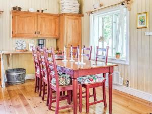 uma cozinha com uma mesa de madeira e cadeiras em Holiday home FLEN IV em Flen