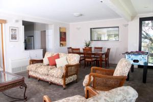 a living room with a couch and chairs and a table at Beachside Entertainer in Apollo Bay