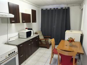 a small kitchen with a table and a microwave at Appartement F1 rez de chausser BG N°2 in Bains-les-Bains