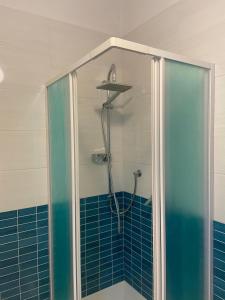 a shower in a bathroom with blue tile at Casa vacanze Brezza di mare in Tortora +29 photos