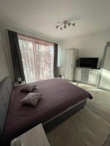 シオーフォクにあるSiófok VIP apartmanのベッドルーム1室(紫のシーツが敷かれたベッド1台、窓付)
