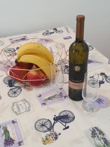 un tavolo con una bottiglia di vino e un cesto di frutta di Janja Apartment a Novigrad Istria