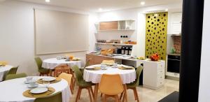 a dining room with two tables and a kitchen at Aroma d in Orca
