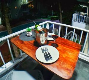 uma mesa de madeira com uma garrafa de vinho e copos em Punta Cana Sol Caribe Beach Pool em Punta Cana