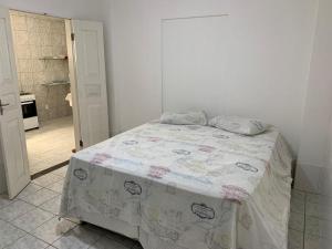 a bedroom with a bed and a kitchen at Apartamento charmoso próximo ao Centro in Vitória da Conquista