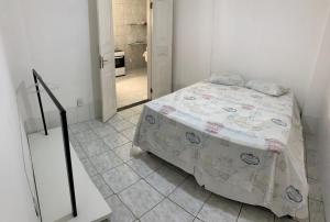 um quarto com uma cama e piso em azulejo em Apartamento charmoso próximo ao Centro em Vitória da Conquista