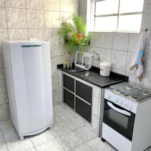 uma cozinha com um fogão e um frigorífico branco em Apartamento charmoso próximo ao Centro em Vitória da Conquista