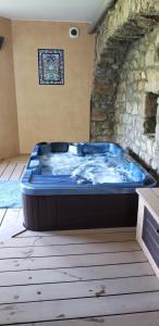 a large blue tub in a room with a stone wall at MaDolceVia Chambres d'hôtes au coeur de Lamastre in Lamastre
