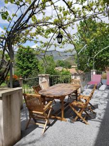 a wooden table and chairs on a patio at MaDolceVia Chambres d'hôtes au coeur de Lamastre in Lamastre