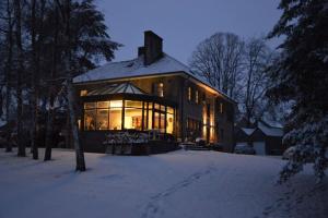 a large house in the snow at night at Au Clos Caleste in Wellin