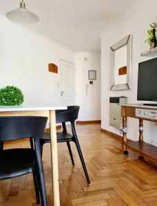 a dining room with a table and chairs and a television at Departamento Nueva Córdoba RW in Cordoba