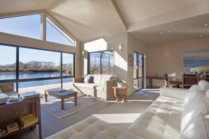 a living room with a white couch and large windows at Matuka Lodge in Twizel