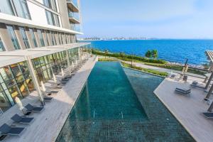 ドバイにあるPremium 2+1 BR condo in the heart of Bluewaters Islandの海辺のスイミングプール付きの建物