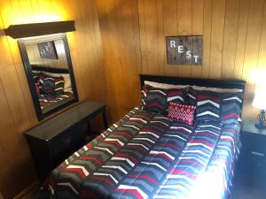 a bed in a room with a wooden wall at High Country Lodge in Alto