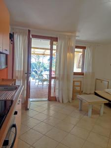 eine Küche und ein Wohnzimmer mit einem Tisch und einem Sofa in der Unterkunft Casa Vacanza Baja Sardinia in Baja Sardinia