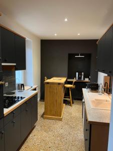 uma grande cozinha com uma mesa e uma bancada em Superbe appartement avec mobilier luxueux. em Morbier