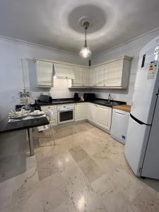 uma cozinha com armários brancos e um frigorífico branco em DREAM BULEVAR em Santa Cruz de Tenerife