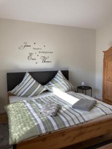 a bedroom with a bed with a sign on the wall at Apartment Panoramablick in Bad Bergzabern