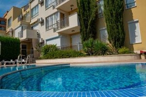 a swimming pool in front of a building at Menada Belle View Apartments in Sveti Vlas