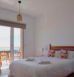 - une chambre avec un grand lit blanc et un balcon dans l'établissement Casa Ninive, à Fuencaliente de la Palma