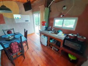 a kitchen with a counter and a table and a table and a kitchen at ECOCABAÑAS CERRO ARKO in Mendoza +16 photos