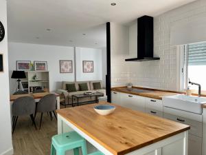 a kitchen with a counter top and a living room at Apartamentos La Higuera 1 in Rota