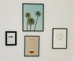 a wall with four framed pictures of palm trees at Casa Ninive in Fuencaliente de la Palma