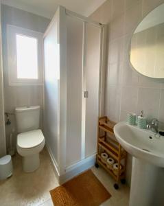 a white bathroom with a toilet and a sink at Casa Ninive in Fuencaliente de la Palma