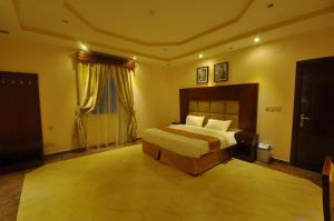 a large bedroom with a bed and a window at Kinda Suites in Taif