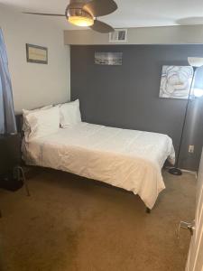 a bedroom with a large bed with white sheets at Rooms in centrally located home in Charlotte