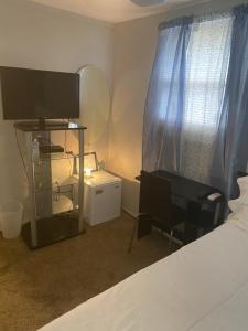 a bedroom with a bed and a desk and a television at Rooms in centrally located home in Charlotte