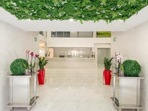 a lobby with two vases with flowers in it at Hotel Aviación in Manises