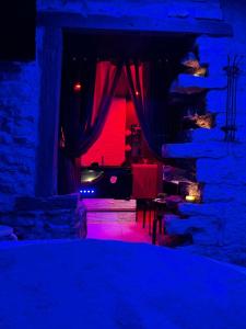 ein dunkles Zimmer mit einer Steinmauer mit roten und blauen Lichtern in der Unterkunft Cosyroom25 in Besançon