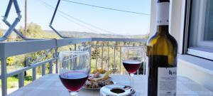 - une bouteille de vin et deux verres sur une table dans l'établissement Spiros - Full Renovated House 2022, à Mármaron