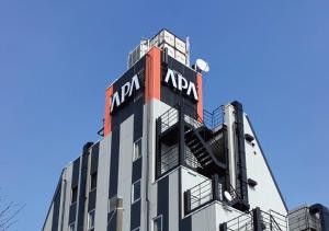 Un bâtiment avec un panneau en haut dans l'établissement APA Hotel Hachioji Eki Kita, à Hachioji