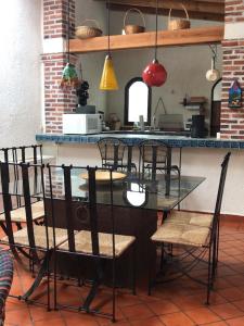 ein Esszimmer mit einem Glastisch und Stühlen in der Unterkunft Finca Las Palmas in Malinalco