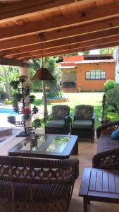 eine Terrasse mit Stühlen, einem Tisch und einem Sonnenschirm in der Unterkunft Finca Las Palmas in Malinalco