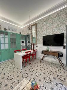 kuchnia z zielonymi szafkami i stołem z czerwonymi krzesłami w obiekcie Apartamentos El Mar Azul 5 El Bajondillo Torremolinos w mieście Torremolinos