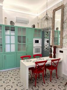 kuchnia z zielonymi szafkami i stołem z czerwonymi krzesłami w obiekcie Apartamentos El Mar Azul 5 El Bajondillo Torremolinos w mieście Torremolinos