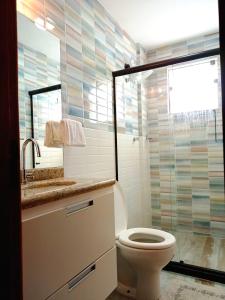 a bathroom with a toilet and a glass shower at Apartbuzios - Apartamentos Completos Búzios - 600mt Rua das Pedras in Búzios