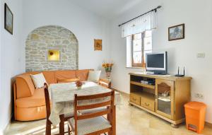 sala de estar con sofá y mesa con TV en Beautiful Apartment In Rakalj With House A Panoramic View, en Rakalj