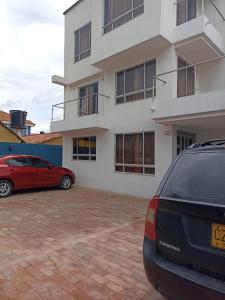 un coche rojo estacionado frente a un edificio en Tauko tu casa, en Paipa