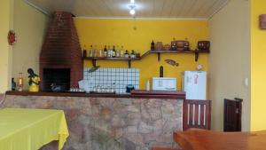 Village Pousada Canedo في غايبيم: مطبخ ذو جدار أصفر مع مدفأة